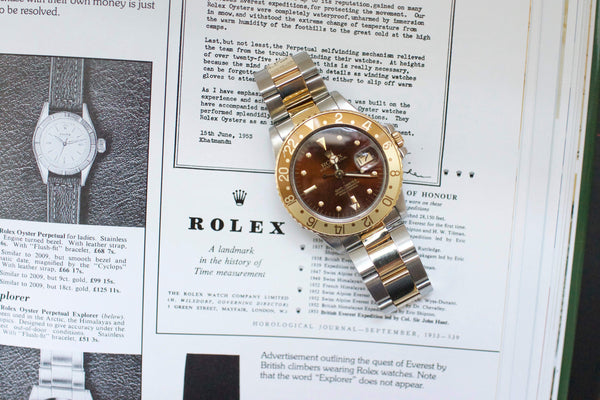 Vintage Rolex GMT 1675 Root Beer watch with brown and gold bezel on magazine background