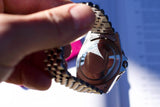 Close-up of the case back and jubilee bracelet of a luxury Swiss watch held in a hand.