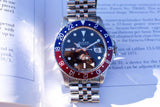 Rolex GMT-Master II luxury watch with a red and blue bezel and jubilee bracelet.