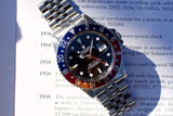 Rolex GMT-Master II luxury watch with blue and red bezel on a printed document