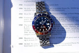 Rolex GMT-Master II luxury watch with Pepsi bezel on a printed document.