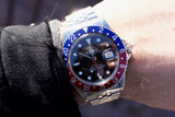 Close-up of a Rolex GMT-Master II with a red and blue Pepsi bezel on a person's wrist.