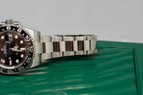 Close-up of a luxury stainless steel GMT watch with black and blue bezel on green box