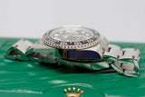 Close-up of luxury stainless steel GMT watch with black and blue bezel on green box