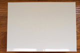 White luxury watch box with embossed crown logo on wooden surface