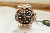Two-tone luxury GMT watch with black and brown bezel and date display on a document