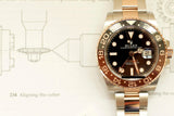 Two-tone Rolex GMT-Master II Root Beer watch with black and brown bezel on technical drawing background