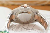 Close-up of a two-tone luxury Swiss watch case back and bracelet on technical drawings