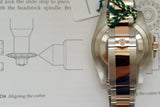 Close-up of luxury two-tone watch bracelet with crown logo clasp, case back view