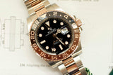 Two-tone GMT luxury watch with black dial and rose gold ceramic bezel on metal bracelet
