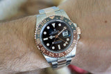 Two-tone Rolex GMT-Master II Root Beer watch with black dial and ceramic bezel on wrist