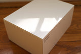 White watch box with Oyster M SAP-39139 label on wooden surface