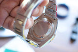 Close-up of the stainless steel case back and metal bracelet of a luxury Swiss watch