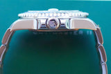 Side profile of a luxury stainless steel Swiss watch with a crown and fluted bezel