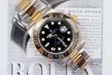 Two-tone Rolex GMT-Master II watch with black dial and ceramic bezel on a magazine background
