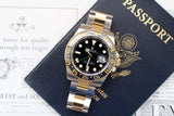 Two-tone Rolex GMT-Master II luxury watch with black dial on a US passport and papers