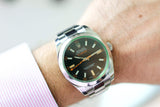 Stainless steel Rolex Milgauss with black dial and green sapphire crystal on wrist