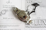 Stainless steel luxury watch with oyster bracelet placed on vintage watch ads