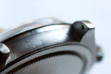 Close-up view of the polished stainless steel bezel and case of a luxury Swiss watch.