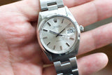 Close-up of a silver Rolex Oysterdate Precision luxury watch on a person's wrist.