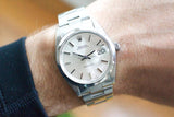 Close-up of a Rolex Oysterdate Precision luxury watch with a silver dial on a wrist