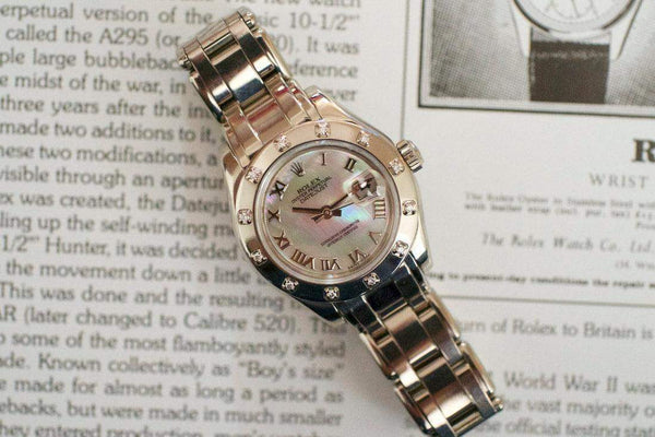 Luxury Swiss-made women's watch with diamond bezel and mother-of-pearl dial on open text