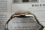 Side view of a women's luxury Swiss watch with diamond bezel and metal bracelet