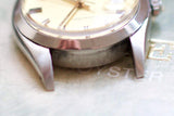 Close-up of luxury Swiss-made watch case with serial number engraving and cream dial