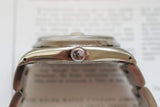 Close-up side view of a stainless steel luxury wristwatch crown and case