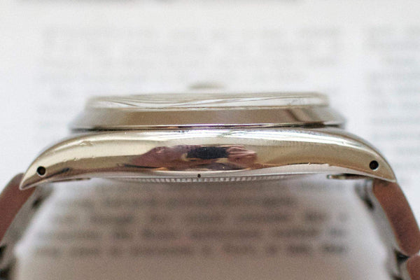 Close-up of vintage Swiss watch polished stainless steel case side profile