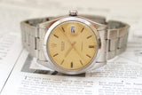 Vintage Rolex Oysterdate Precision 6694 watch with cream dial and steel bracelet on paper background