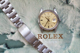 Vintage Rolex Oysterdate Precision 6694 with cream dial and stainless steel bracelet on textured background