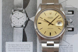 Vintage stainless steel watch with cream dial and date window on a metal bracelet, close-up