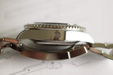 Close-up side view of a stainless steel luxury dive watch with a rotating bezel and bracelet.