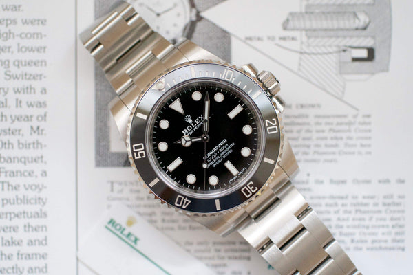 Stainless steel luxury Swiss dive watch with black dial and unidirectional bezel on documents