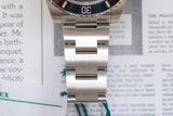 Close-up of stainless steel dive watch bracelet and bezel on paper background