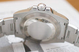 Close-up of stainless steel luxury watch case back and bracelet on a document