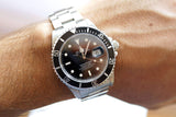 Rolex Submariner luxury dive watch with black dial and silver steel band on a wrist