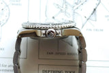 Side view of a luxury Swiss dive watch with a stainless steel bracelet.