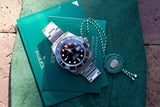 Rolex Submariner luxury watch with green warranty box and certification seal
