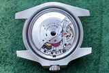 Internal view of a luxury Swiss watch movement inside a silver stainless steel case