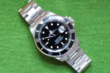 Rolex Submariner luxury dive watch with black dial and stainless steel bracelet on green fabric