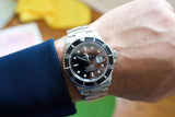 Close-up of a Rolex Submariner Date luxury watch with black dial and silver steel bracelet
