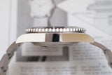 Side view of stainless steel dive watch with ceramic bezel and link bracelet