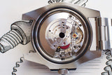 Close-up of luxury mechanical watch movement with visible gears and rotor in stainless steel case