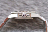 Side view of a luxury stainless steel watch case with a detailed crown logo on the crown