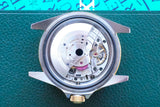 Close-up of an open luxury Swiss watch movement showing internal gears and mechanisms.