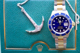 Rolex Submariner Date luxury watch with blue bezel and silver anchor pendant on green leather