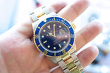 Rolex Submariner Date luxury watch with blue bezel and two-tone gold and steel bracelet