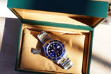 Rolex GMT-Master II luxury watch with blue bezel in a green presentation box